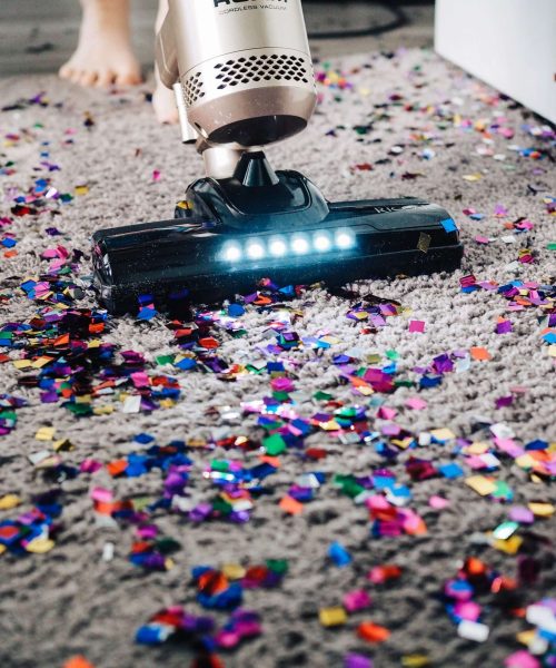 a person using a vacuum to clean a carpet